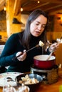Young adult woman eating fondue at restaurant Royalty Free Stock Photo