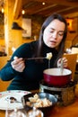 Young adult woman eating fondue at restaurant Royalty Free Stock Photo