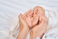 Young adult woman holding little new born baby feet in hands Royalty Free Stock Photo