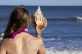 Young adult woman holding a triton seashell Royalty Free Stock Photo