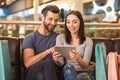 Young adult woman and man using tablet in fashionable store