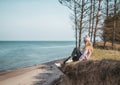 Young adult woman in pink hat sitting alone on the bluffs, looking of sea, freedom concept, peaceful atmosphere Royalty Free Stock Photo