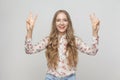 Young adult woman showing peace sign and toothy smiling Royalty Free Stock Photo