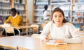 Young adult woman studying in public library Royalty Free Stock Photo