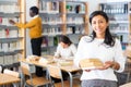 Young adult woman studying in public library Royalty Free Stock Photo