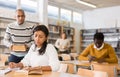 Young adult woman studying in public library Royalty Free Stock Photo