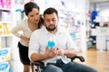 Man in wheelchair and woman in drugstore