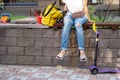 Young adult woman wearing casual clothes sitting on wooden bench at children playground and looking after playing kids on warm Royalty Free Stock Photo