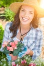 Young Adult Woman Wearing Hat and Gloves Gardening Outdoors