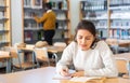 Young adult woman studying in public library Royalty Free Stock Photo