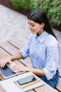 Young adult woman working on laptop sitting outside business office Royalty Free Stock Photo