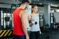 Young adult woman working out in gym with trainer Royalty Free Stock Photo