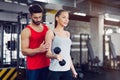 Young adult woman working out in gym with trainer Royalty Free Stock Photo