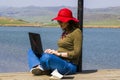 Young adult woman working in the park near lake