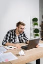 Young adult worker rejoiced and sitting in office