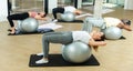 Young adults exercising with gym balls during pilates class Royalty Free Stock Photo