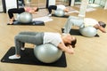 Young adults exercising with gym balls during pilates class Royalty Free Stock Photo