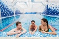 Young adults having fun talking in swimming pool indoors Royalty Free Stock Photo
