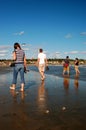 Young adults wade in low tide