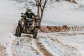 A young adventurous couple embraces the joy of love and thrill as they ride an ATV Quad through the snowy mountainous