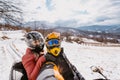 A young adventurous couple embraces the joy of love and thrill as they ride an ATV Quad through the snowy mountainous