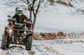 A young adventurous couple embraces the joy of love and thrill as they ride an ATV Quad through the snowy mountainous