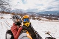 A young adventurous couple embraces the joy of love and thrill as they ride an ATV Quad through the snowy mountainous