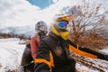 A young adventurous couple embraces the joy of love and thrill as they ride an ATV Quad through the snowy mountainous