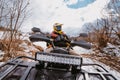 A young adventurous couple embraces the joy of love and thrill as they ride an ATV Quad through the snowy mountainous