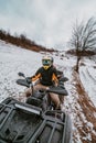 A young adventurous couple embraces the joy of love and thrill as they ride an ATV Quad through the snowy mountainous