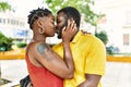 Young afircan american couple hugging and kissing standing at the city