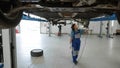 Young aframerican girl working under car bottom