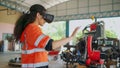 Young Africa American engineer is controlling Futuristic robotic arm with a virtual reality Headset. Testing robot by moving hand