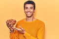 Young african amercian man holding bowl with almonds looking positive and happy standing and smiling with a confident smile Royalty Free Stock Photo