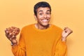 Young african amercian man holding bowl with almonds screaming proud, celebrating victory and success very excited with raised arm Royalty Free Stock Photo