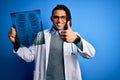 Young african american afro doctor man with dreadlocks holding chest lung xray happy with big smile doing ok sign, thumb up with