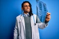 Young african american afro doctor man with dreadlocks holding chest lung xray with a happy face standing and smiling with a Royalty Free Stock Photo