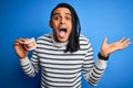 Young african american afro man holding plastic teeth with dental braces very happy and excited, winner expression celebrating Royalty Free Stock Photo