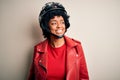 Young African American afro motorcyclist woman with curly hair wearing motorcycle helmet looking away to side with smile on face, Royalty Free Stock Photo