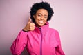 Young African American afro sportswoman with curly hair wearing sportswear doin sport doing happy thumbs up gesture with hand