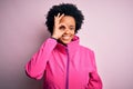 Young African American afro sportswoman with curly hair wearing sportswear doin sport doing ok gesture with hand smiling, eye