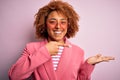 Young African American afro woman with curly hair wearing funny hearts sunglasses amazed and smiling to the camera while Royalty Free Stock Photo