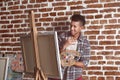 Young African-American artist painting picture in workshop Royalty Free Stock Photo