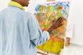 Young african american artist woman smiling happy painting with hands at art studio