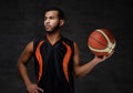 Young African-American basketball player in sportswear isolated over dark background. Royalty Free Stock Photo