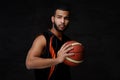 Young African-American basketball player in sportswear isolated over dark background. Royalty Free Stock Photo