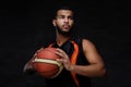 Young African-American basketball player in sportswear isolated over dark background. Royalty Free Stock Photo