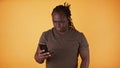 Young african american black man reading messages on his smartphone Royalty Free Stock Photo