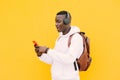 Young african American black man with surprise face looking at smart phone while listening music with wireless headphones Royalty Free Stock Photo