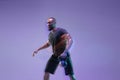 Young african-american bodybuilder training over purple background in neon, mixed light Royalty Free Stock Photo